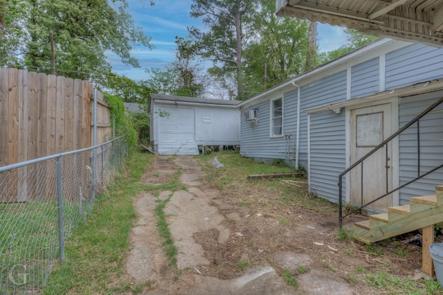 view of yard with a garage, fence, and an outdoor structure