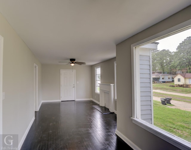 entryway featuring wood finished floors, baseboards, and a ceiling fan