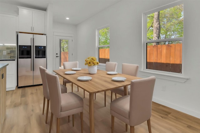 dining room featuring light wood finished floors, baseboards, and recessed lighting