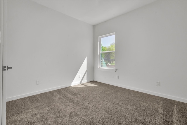 carpeted spare room featuring baseboards