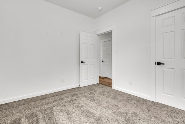 unfurnished bedroom with baseboards and carpet