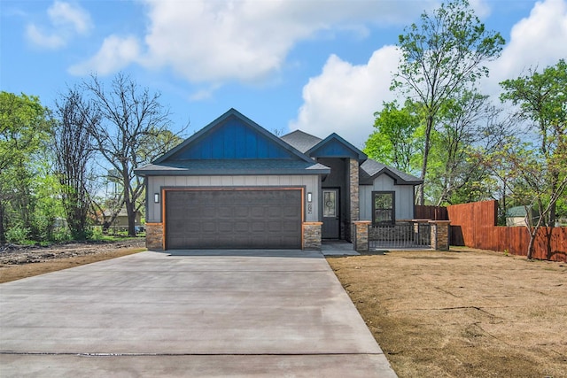 craftsman-style home with concrete driveway, stone siding, board and batten siding, an attached garage, and fence