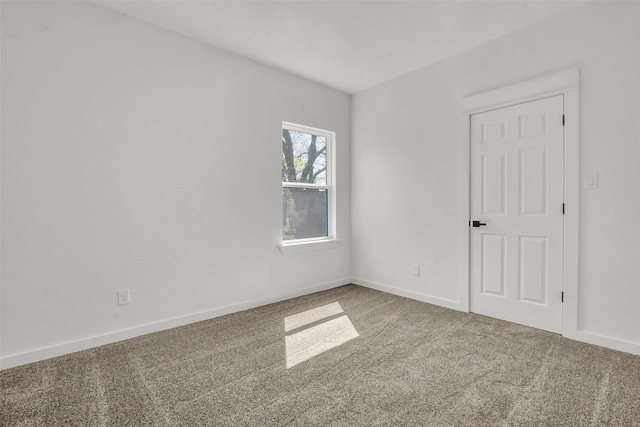 carpeted empty room featuring baseboards