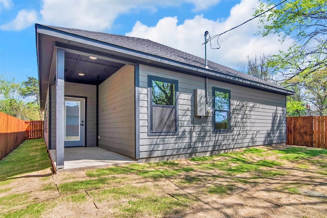 view of property exterior with a fenced backyard, a patio, and a lawn