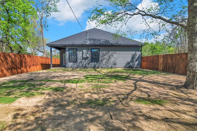 rear view of property with roof with shingles and a fenced backyard