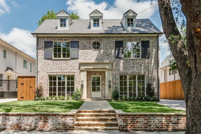 view of front of home featuring brick siding and a gate
