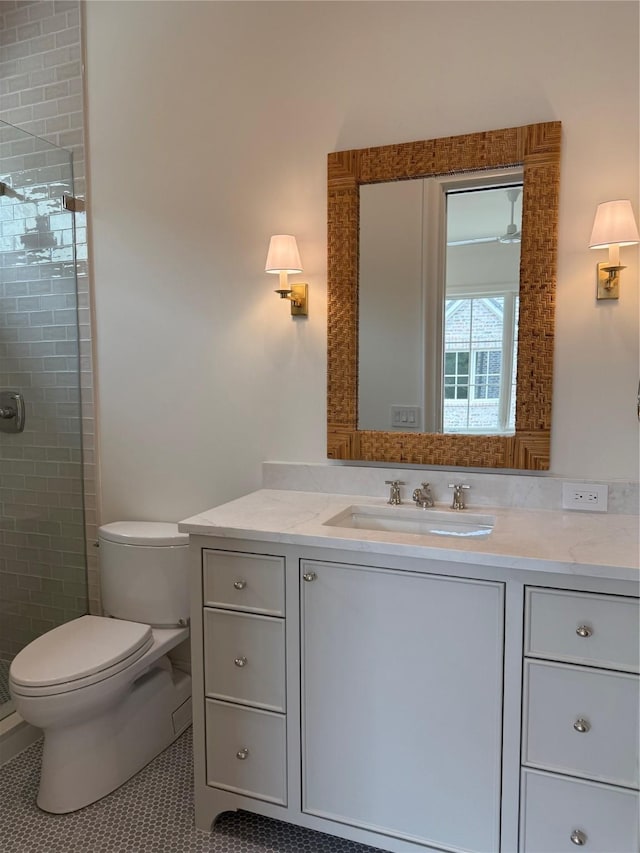 bathroom featuring a shower stall, toilet, vanity, and tile patterned floors
