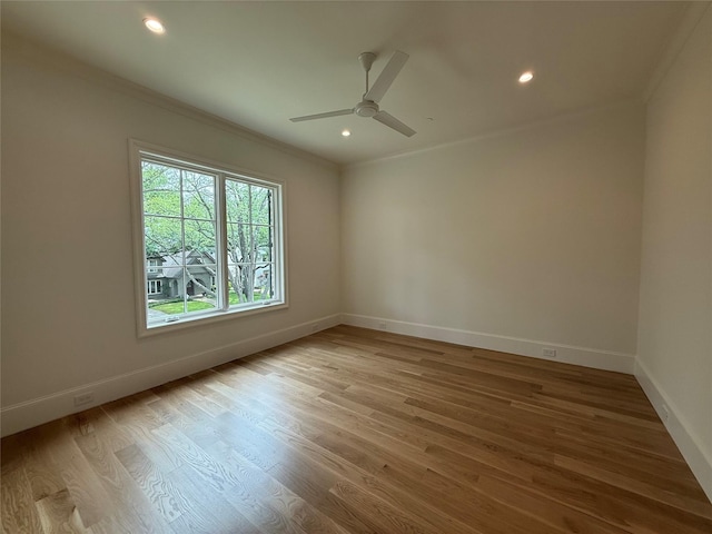 spare room with ornamental molding, baseboards, a ceiling fan, wood finished floors, and recessed lighting