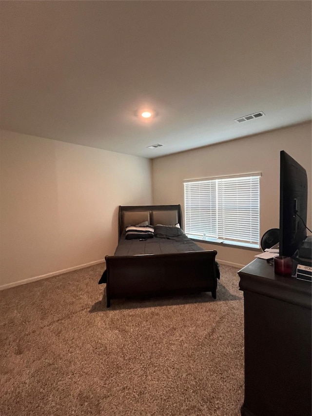 carpeted bedroom featuring visible vents and baseboards