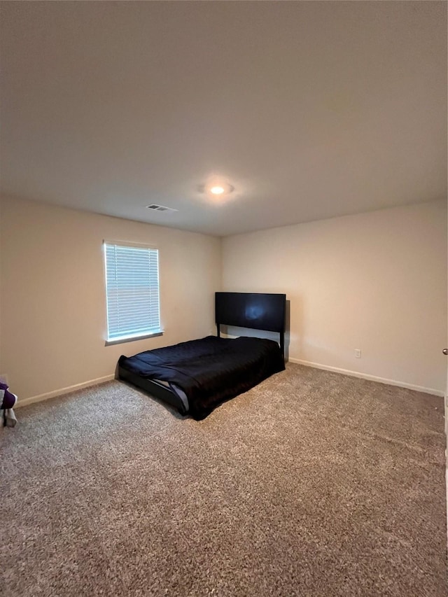 carpeted bedroom featuring visible vents and baseboards