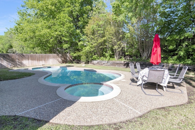 view of pool with a patio area, a pool with connected hot tub, and a fenced backyard