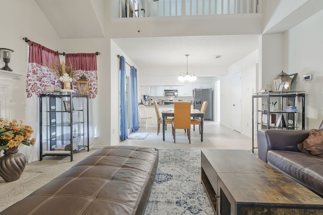 living area with a chandelier, light tile patterned floors, and a towering ceiling