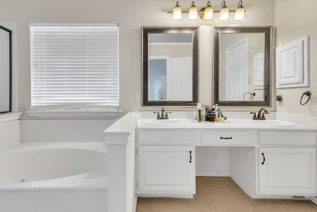 full bathroom featuring double vanity, a jetted tub, tile patterned floors, and a sink