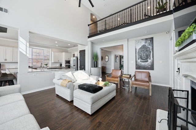 living area featuring baseboards, a high ceiling, dark wood finished floors, and visible vents