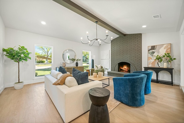 living room with light wood-type flooring, lofted ceiling with beams, a chandelier, a fireplace, and visible vents