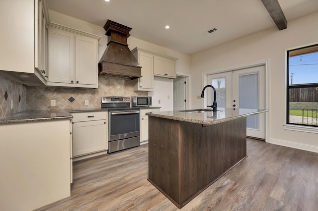 2312 Royce Dr, Arlington, TX 76016 - kitchen with custom range hood, light wood-type flooring, visible vents, appliances with stainless steel finishes, and a sink