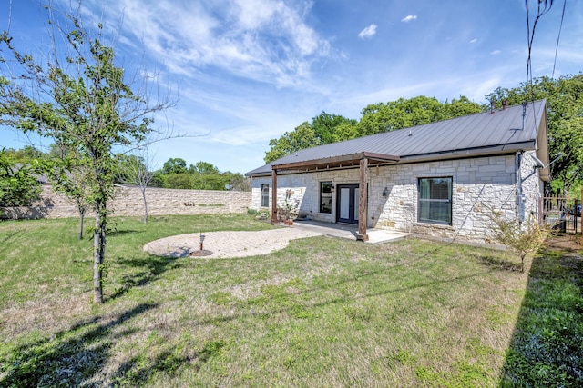 2312 Royce Dr, Arlington, TX 76016 - back of property featuring a patio, metal roof, stone siding, and a lawn