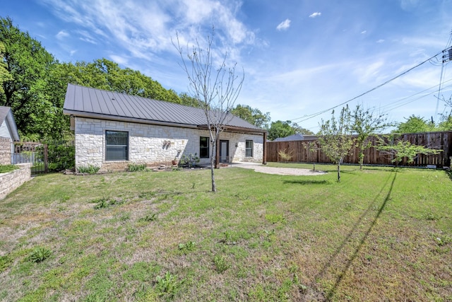 2312 Royce Dr, Arlington, TX 76016 - back of property with a yard, stone siding, and metal roof
