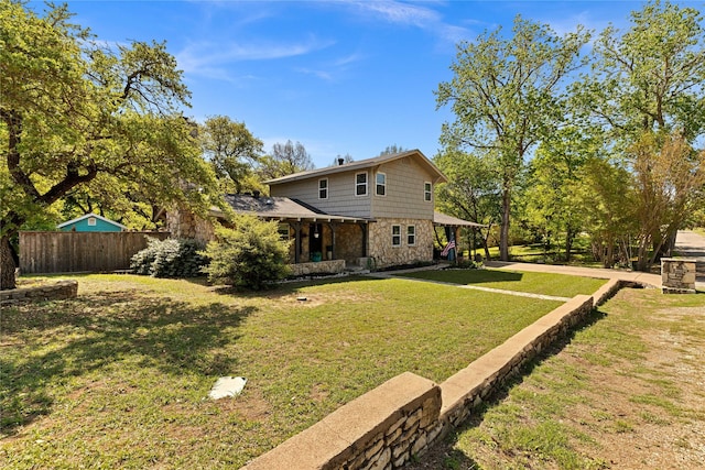 exterior space featuring a yard, fence, and stone siding