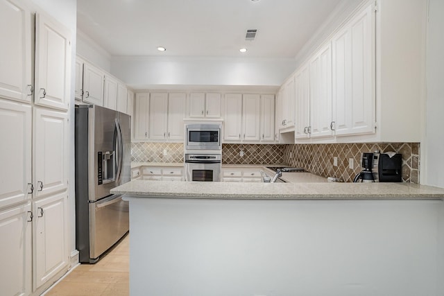 3422 Lovers Ln Unit A, University Park, TX 75225 - kitchen with stainless steel appliances, a peninsula, decorative backsplash, white cabinets, and light wood finished floors