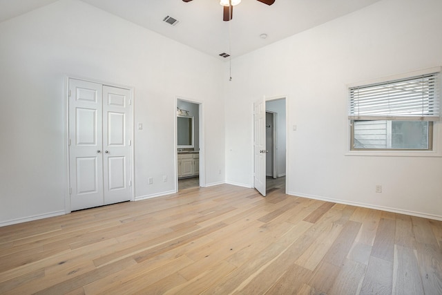 3422 Lovers Ln Unit A, University Park, TX 75225 - unfurnished bedroom with light wood-style floors, a towering ceiling, baseboards, connected bathroom, and a ceiling fan