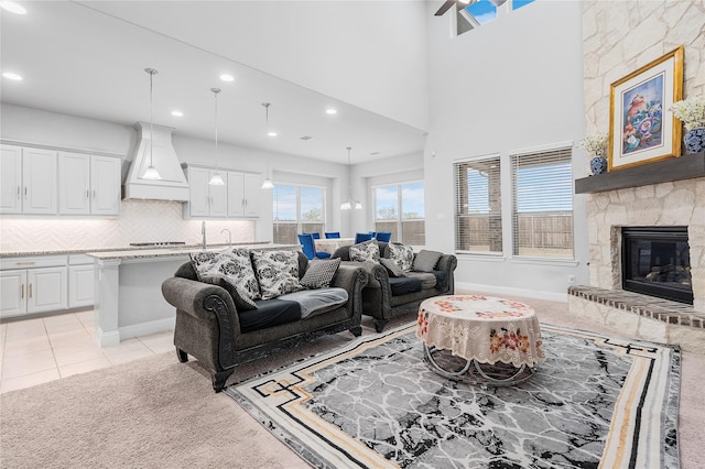 living room featuring light carpet, light tile patterned floors, a stone fireplace, and recessed lighting