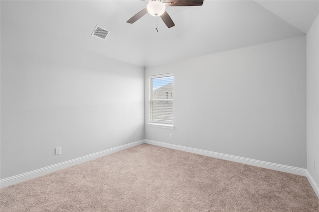 carpeted empty room featuring visible vents, baseboards, a ceiling fan, and lofted ceiling