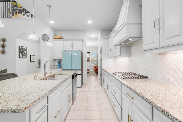 kitchen featuring white cabinets, custom exhaust hood, a sink, and appliances with stainless steel finishes
