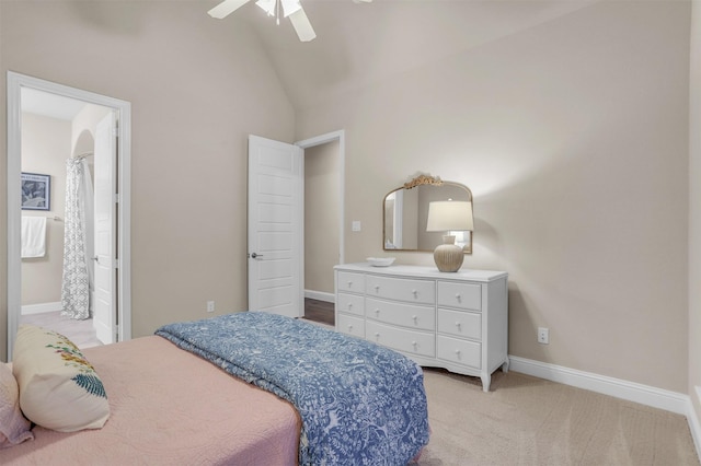 bedroom with baseboards, ceiling fan, ensuite bath, vaulted ceiling, and light colored carpet