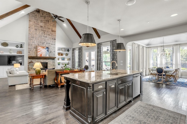 kitchen featuring a sink, built in shelves, dark wood-style floors, and light stone countertops