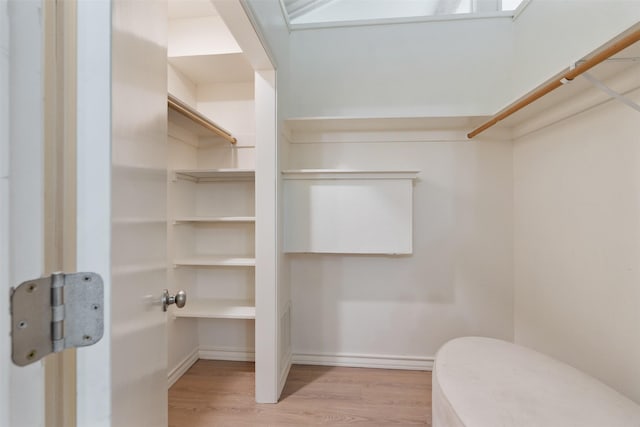 walk in closet with wood finished floors