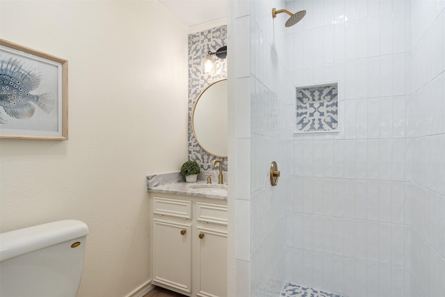 bathroom with vanity, a tile shower, and toilet