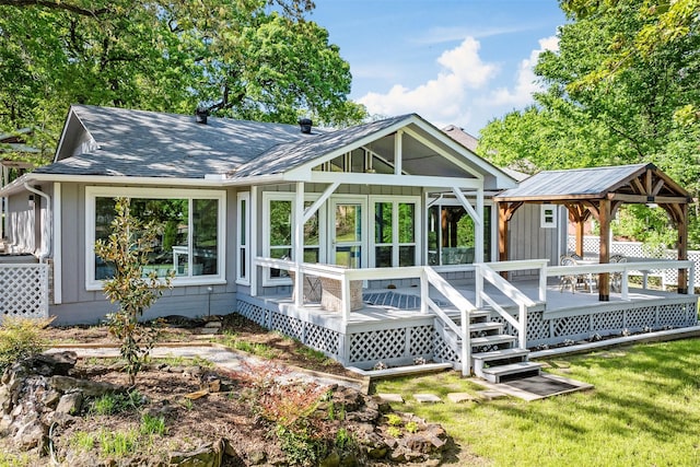 back of house featuring roof with shingles, a gazebo, and a lawn