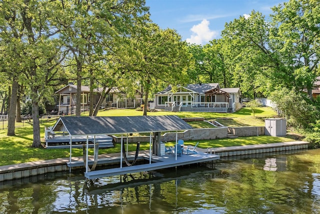 dock area featuring a water view, a yard, and boat lift