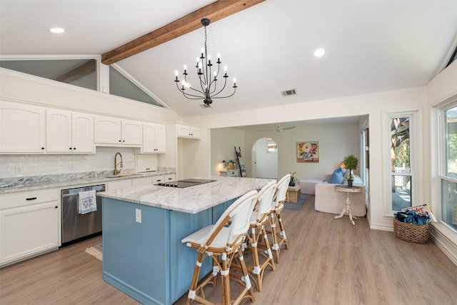 kitchen with beamed ceiling, white cabinetry, light stone counters, dishwasher, and a sink