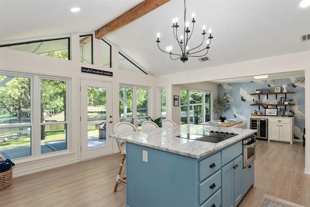5269 Alta Vis, Malakoff, TX 75148 - kitchen featuring wine cooler, black electric stovetop, stainless steel oven, light wood-style floors, and a kitchen bar