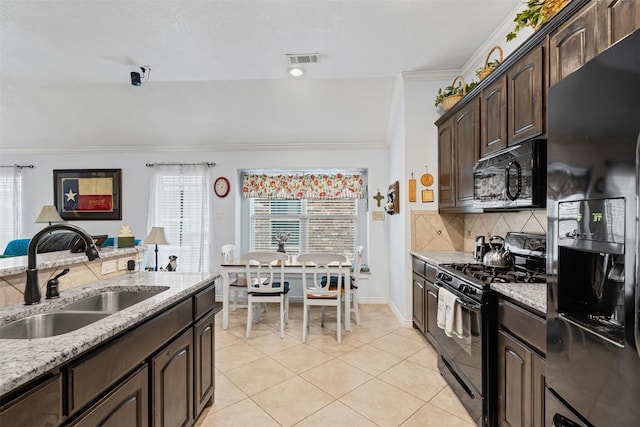 5929 Black Bass Dr, Fort Worth, TX 76179 - kitchen featuring tasteful backsplash, dark brown cabinets, black appliances, light stone countertops, and a sink