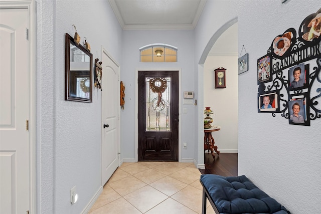 5929 Black Bass Dr, Fort Worth, TX 76179 - foyer entrance with light tile patterned floors, baseboards, arched walkways, a textured wall, and crown molding