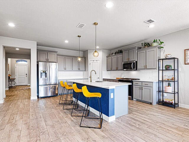 14624 Bootes Dr, Haslet, TX 76052 - kitchen with stainless steel appliances, a sink, gray cabinetry, light wood-style floors, and light countertops