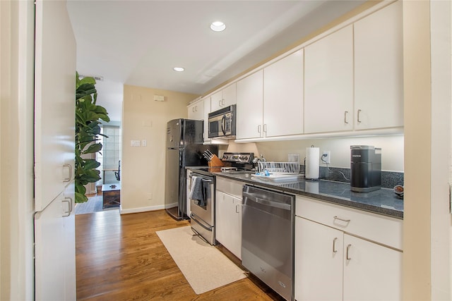 4241 Buena Vista St Unit 14, Dallas, TX 75205 - kitchen with dark stone countertops, recessed lighting, white cabinets, stainless steel appliances, and wood finished floors