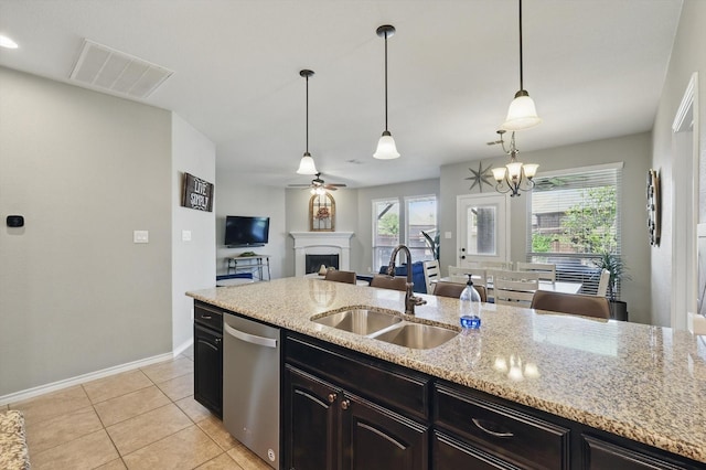 336 Avila Ln, Fort Worth, TX 76052 - kitchen featuring dishwasher, a fireplace, light stone counters, light tile patterned flooring, and hanging light fixtures