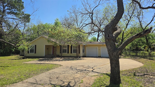 ranch-style house with concrete driveway, fence, a front lawn, and a garage