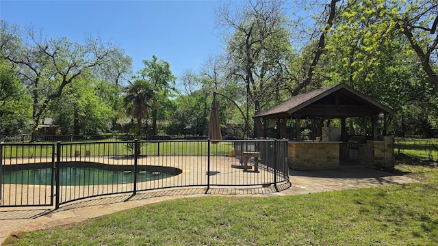 view of community with exterior kitchen, a patio area, a gazebo, fence, and a lawn