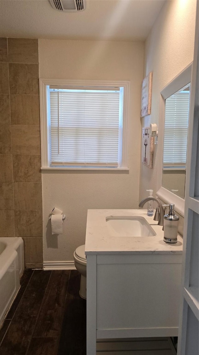 bathroom featuring vanity, visible vents, baseboards, and toilet
