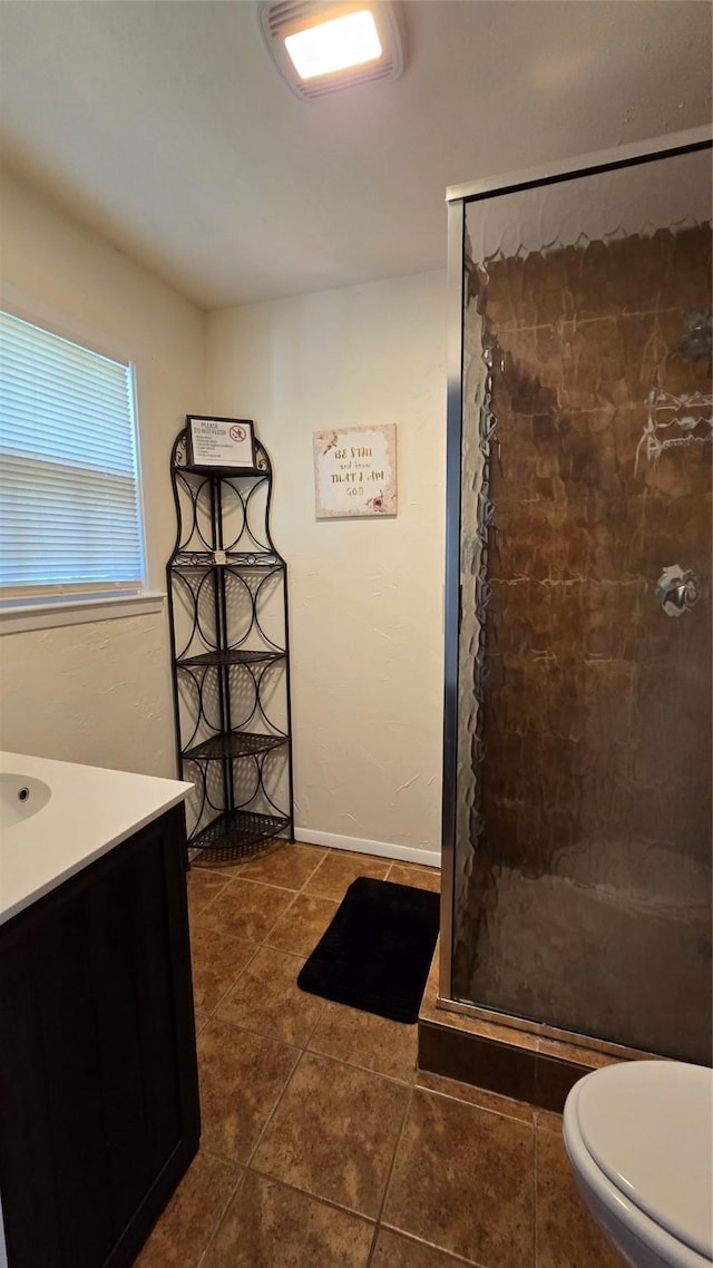full bath featuring baseboards, toilet, a shower stall, vanity, and tile patterned floors