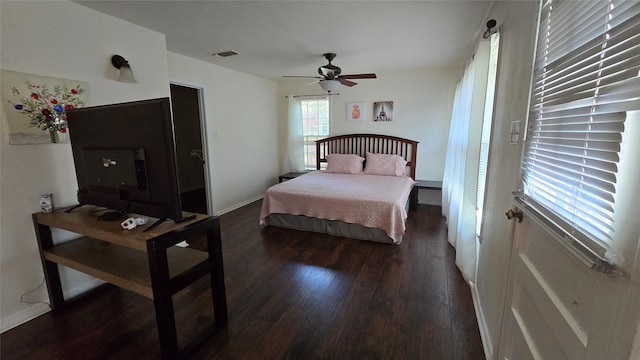 bedroom with wood finished floors, ceiling fan, baseboards, and visible vents