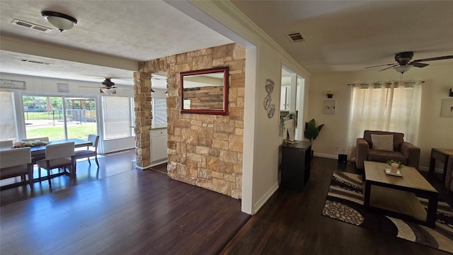 living room with visible vents, a ceiling fan, and dark wood finished floors