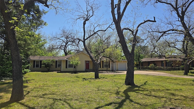 ranch-style home featuring a front lawn, an attached garage, and concrete driveway
