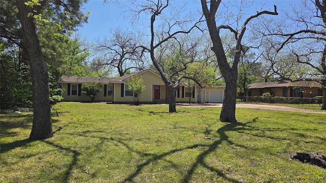 ranch-style home featuring driveway, a front yard, and a garage