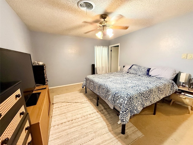 bedroom featuring visible vents, a ceiling fan, carpet floors, and a textured ceiling